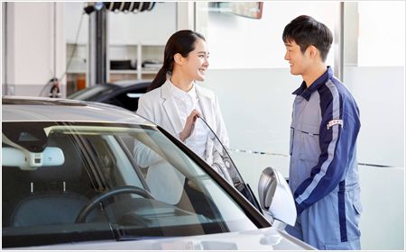 車の傍で話し合う女性とスタッフ